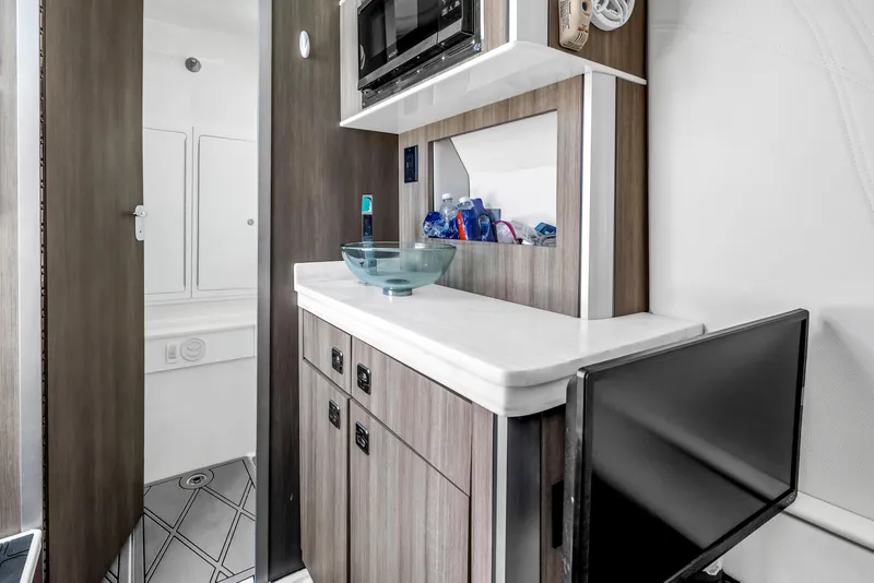 Slide: The Image of Modern boat interior with wood cabinetry, glass sink, and built-in microwave in a 2019 Fountain 43NX. - 24