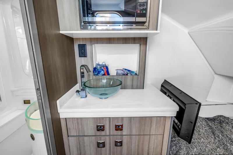 Slide: The Image of Modern boat interior with glass sink, microwave, and storage in 2019 Fountain 43NX model. - 26