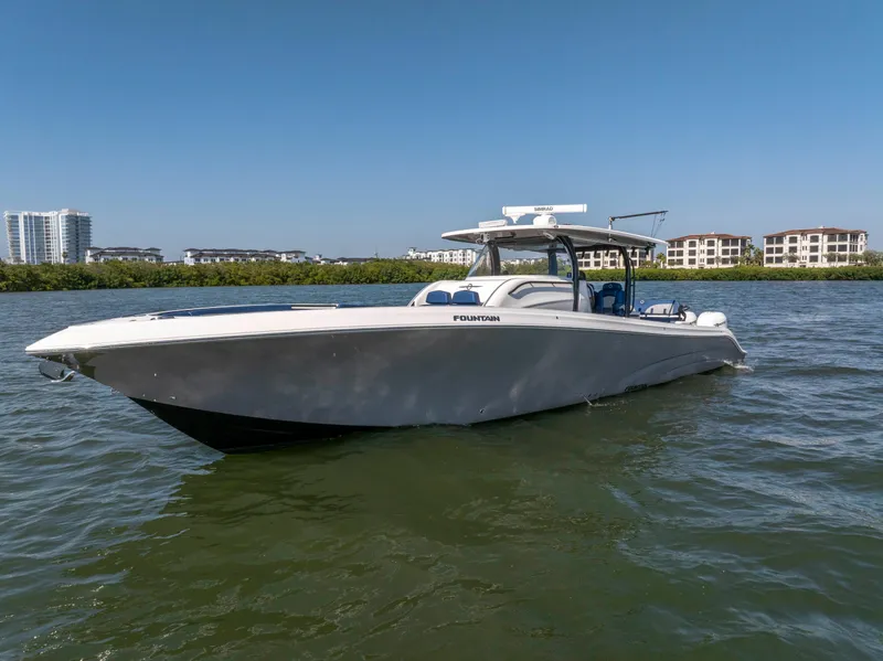 Slide: The Image of 2019 Fountain 43NX boat on water, clear sky, waterfront buildings in background. - 3