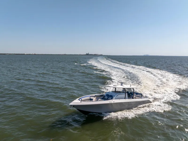 Slide: The Image of 2019 Fountain 43NX boat cruising on open water under clear blue sky. - 4