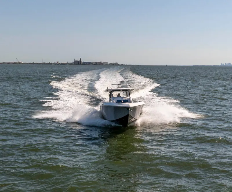 Slide: The Image of 2019 Fountain 43NX boat speeding on open water, leaving a wake behind. - 6