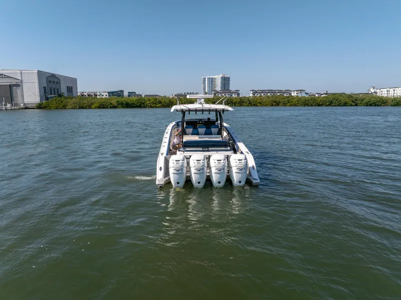 Slide: The Image of Fountain 43NX 2019 boat with four engines cruising on a calm waterway. - 7
