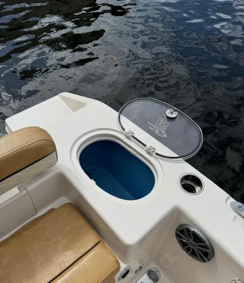 Slide: The Image of 2024 Sea Chaser 24 HFC boat with open storage compartment by the water. - 11