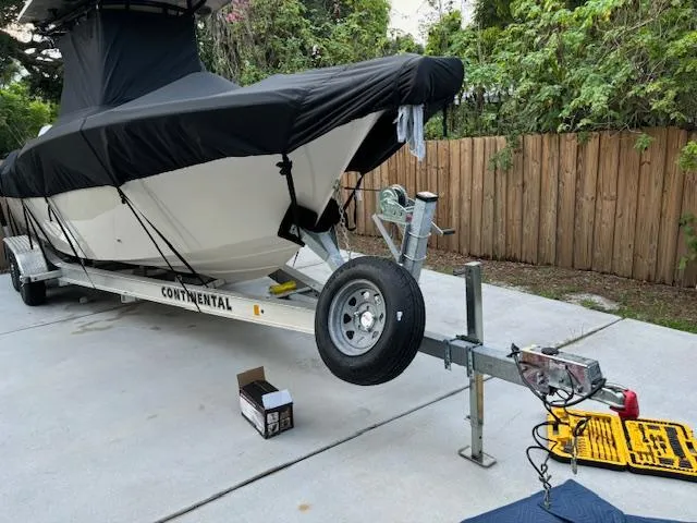 Slide: The Image of 2024 Sea Chaser 24 HFC boat on trailer, covered, parked on concrete driveway. - 17