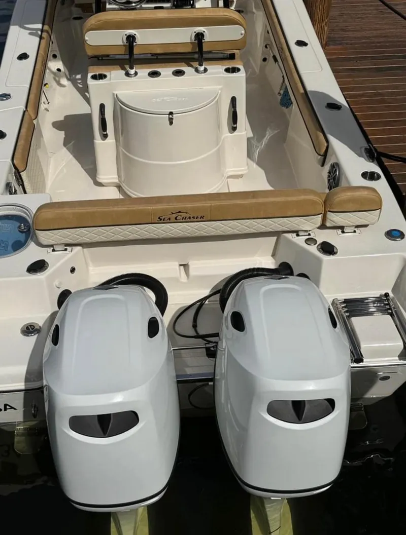 Slide: The Image of 2024 Sea Chaser 24 HFC boat with dual outboard engines, beige seating, and modern design. - 21