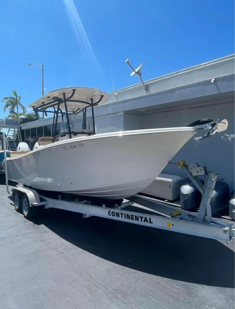 Slide: The Image of 2024 Sea Chaser 24 HFC boat on trailer, parked outdoors under clear blue sky. - 3