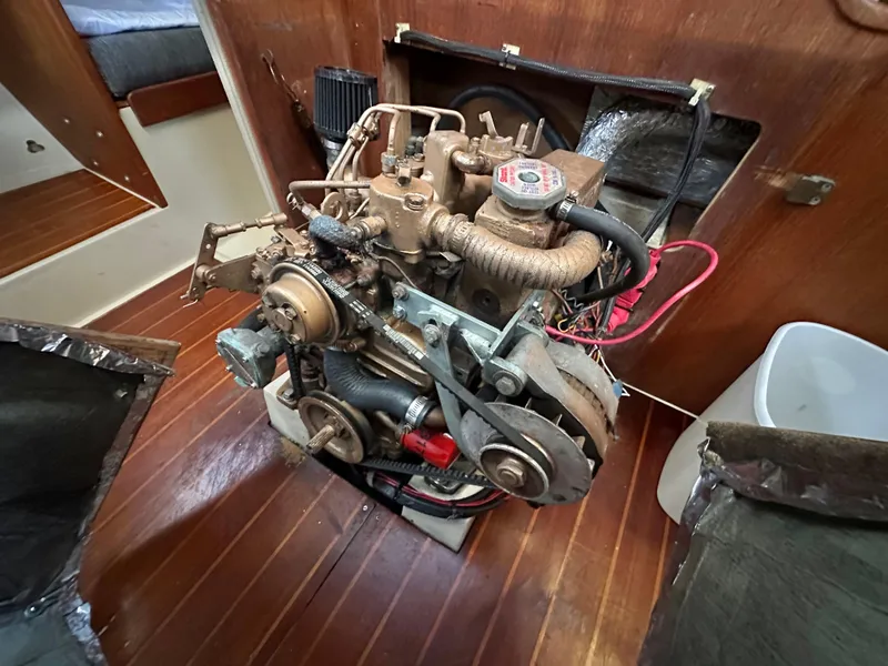 Slide: The Image of Engine compartment of a 1986 Catalina 36 sailboat, showcasing mechanical components and wooden interior. - 10