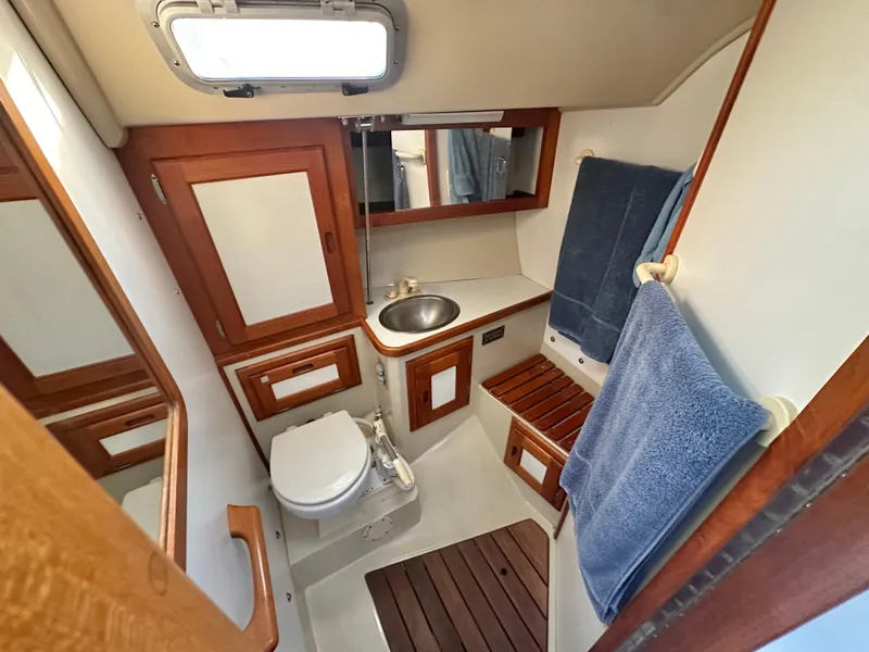 Slide: The Image of 1986 Catalina 36 yacht bathroom with wooden accents, sink, and toilet. - 13