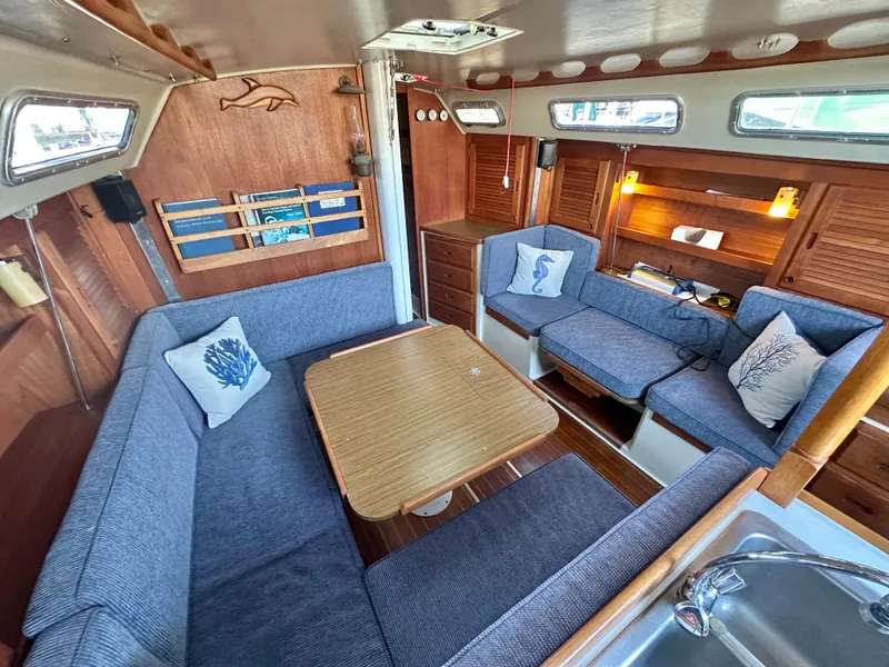 Slide: The Image of Interior of a 1986 Catalina 36 sailboat with cozy seating and wooden accents. - 18