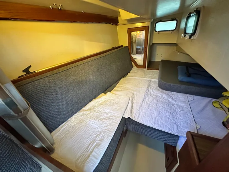 Slide: The Image of Interior of 1986 Catalina 36 sailboat with cozy sleeping area and cushions. - 22