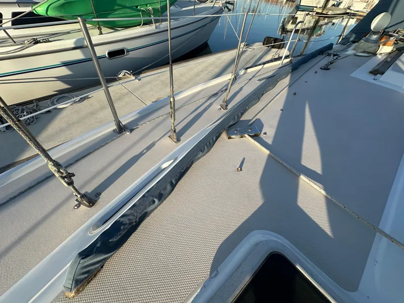 Slide: The Image of 1986 Catalina 36 sailboat deck with railing and moored boats in background. - 26