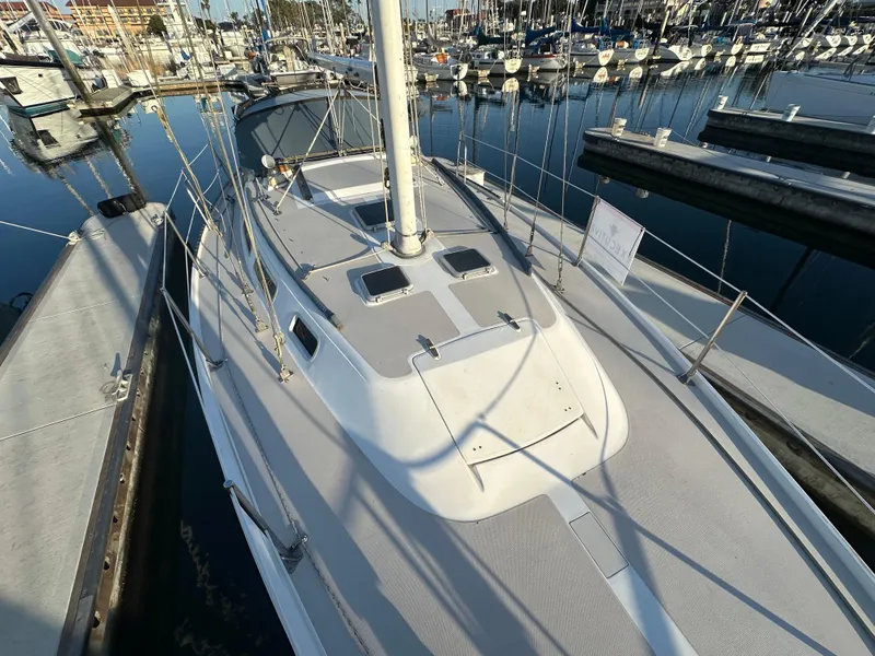 Slide: The Image of 1986 Catalina 36 sailboat docked at marina, showcasing deck and mast. - 27