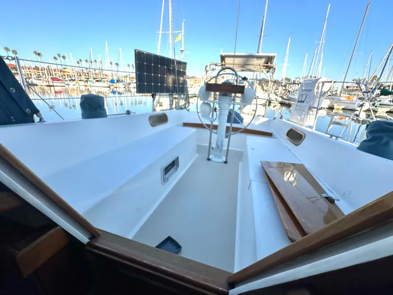 Slide: The Image of 1986 Catalina 36 sailboat cockpit with marina view, featuring solar panels and steering wheel. - 5