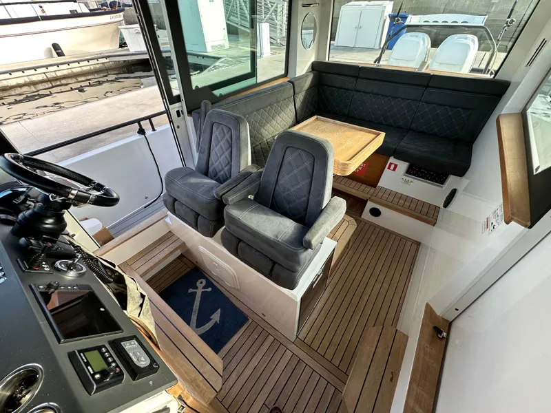 Slide: The Image of 2017 Axopar 37 interior with plush seating and wooden flooring. - 14