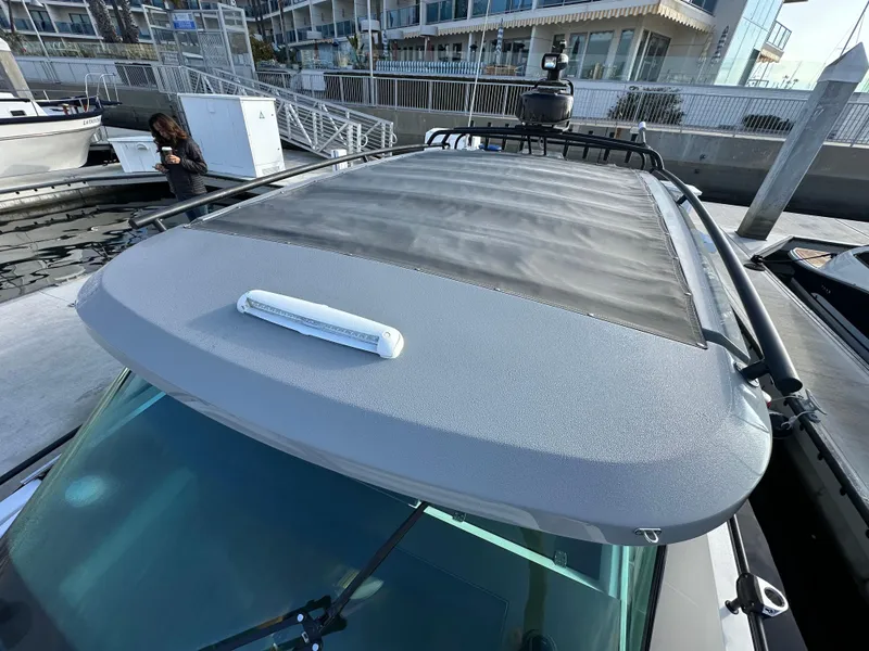 Slide: The Image of 2017 Axopar 37 boat with a sleek roof design at a marina. - 21