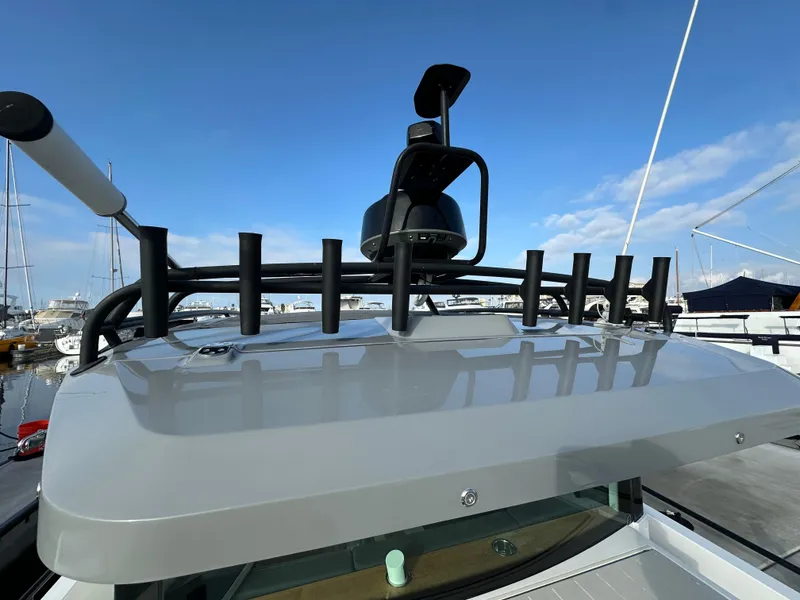 Slide: The Image of 2017 Axopar 37 boat roof with radar and antenna, docked at marina under clear sky. - 26