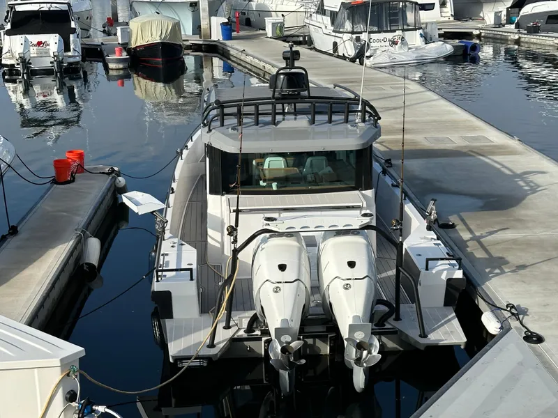 Slide: The Image of 2017 Axopar 37 boat docked at a marina with twin engines. - 30