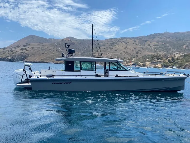 Slide: The Image of 2017 Axopar 37 boat on calm water with scenic mountain backdrop. - 31