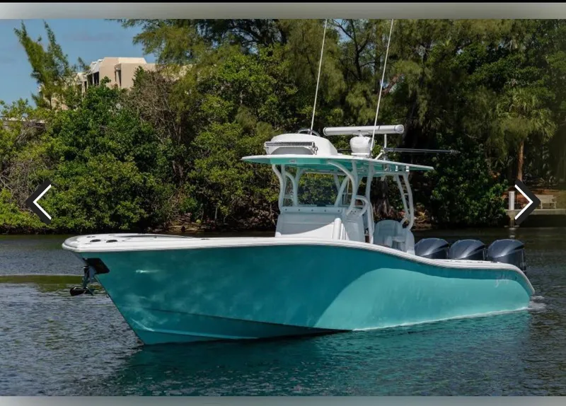 Slide: The Image of 2018 Yellowfin 36 boat on water, surrounded by lush greenery. - 0