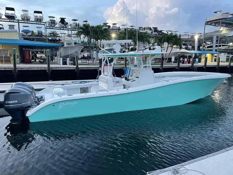 Slide: The Image of 2018 Yellowfin 36 boat docked with Yamaha engine, turquoise hull, and marina background. - 15