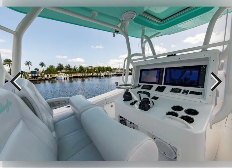Slide: The Image of 2018 Yellowfin 36 boat cockpit with modern navigation system and waterfront view. - 2