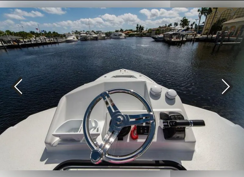 Slide: The Image of 2018 Yellowfin 36 boat helm with marina view, clear skies, and calm waters. - 6