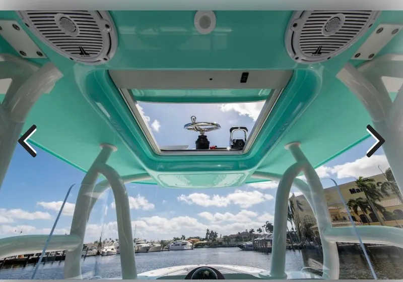 Slide: The Image of 2018 Yellowfin 36 boat interior with speakers, open hatch, and marina view. - 7