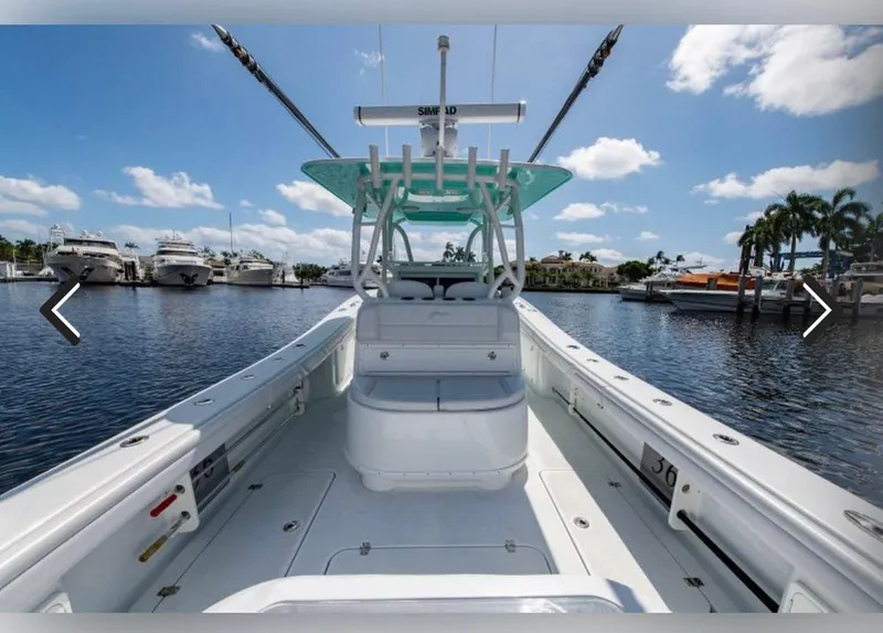 Slide: The Image of 2018 Yellowfin 36 boat on water, clear sky, marina background. - 9