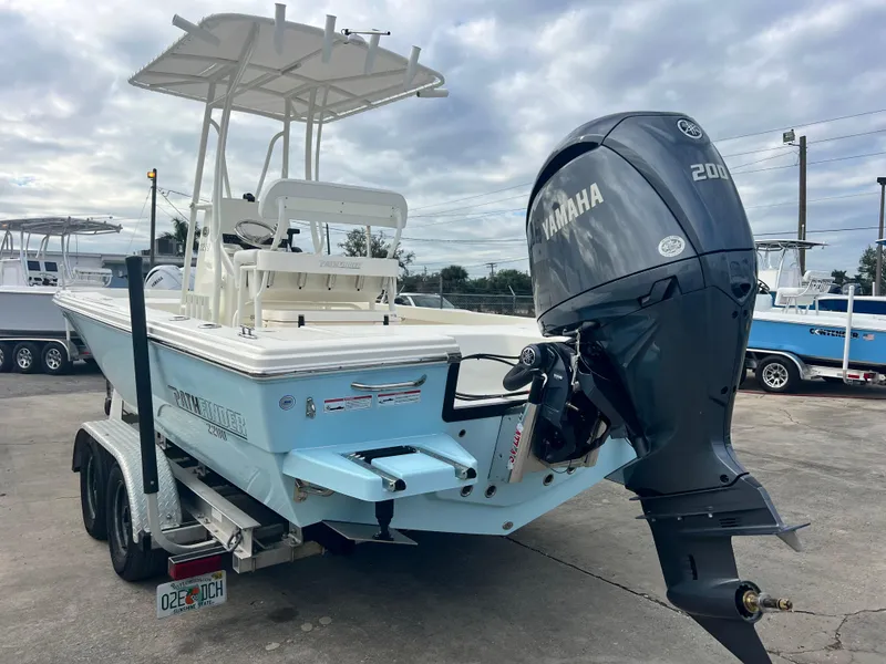 Slide: The Image of 2025 Pathfinder 2200 TRS boat with Yamaha engine on trailer, parked outdoors. - 11