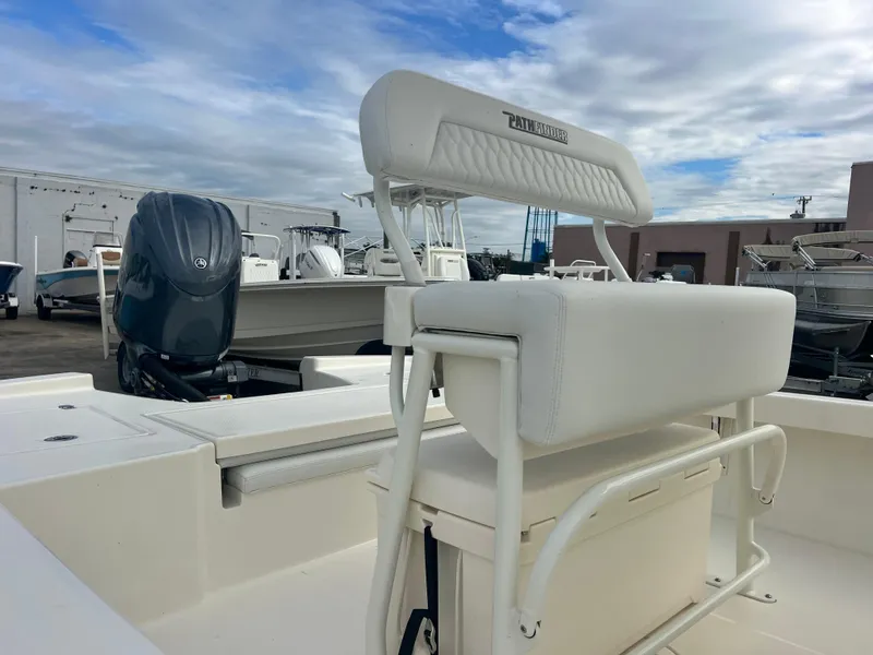 Slide: The Image of 2025 Pathfinder 2200 TRS boat with cushioned seating and outboard motor, docked outdoors. - 3