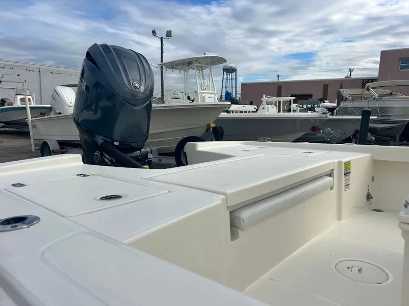 Slide: The Image of 2025 Pathfinder 2200 TRS boat with outboard motor, docked under cloudy sky. - 4