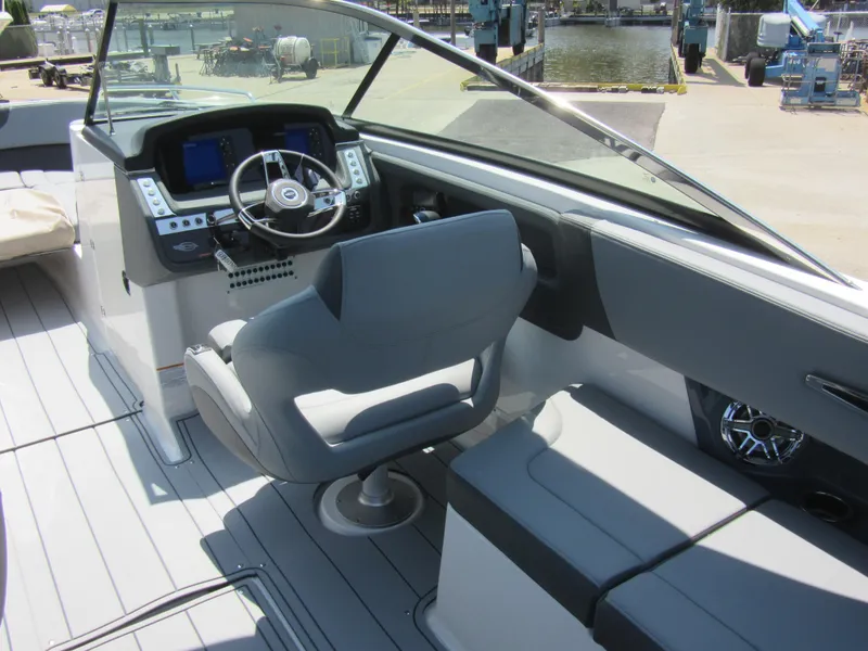 Slide: The Image of 2025 Chaparral 307 SSX boat interior with modern helm and seating, dockside view. - 16