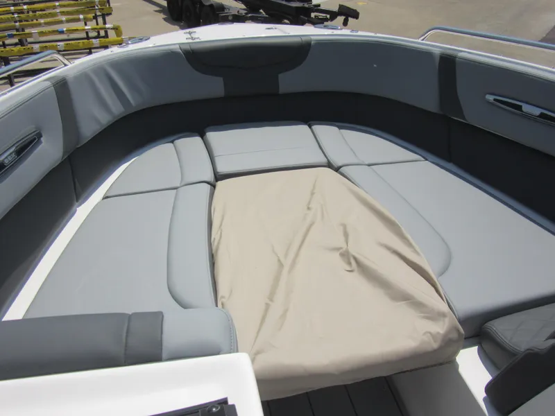 Slide: The Image of 2025 Chaparral 307 SSX boat interior with gray seating and beige cover. - 20