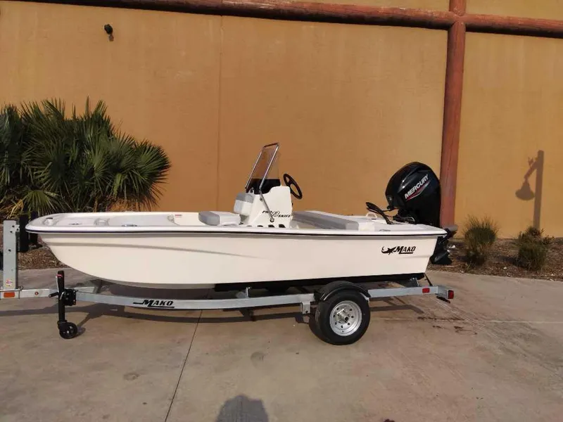 Slide: The Image of 2025 Mako Pro Skiff 13 CC boat on trailer, parked outdoors. - 0