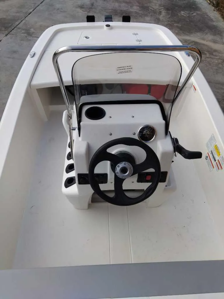 Slide: The Image of 2025 Mako Pro Skiff 13 CC boat interior with steering console and seating. - 1