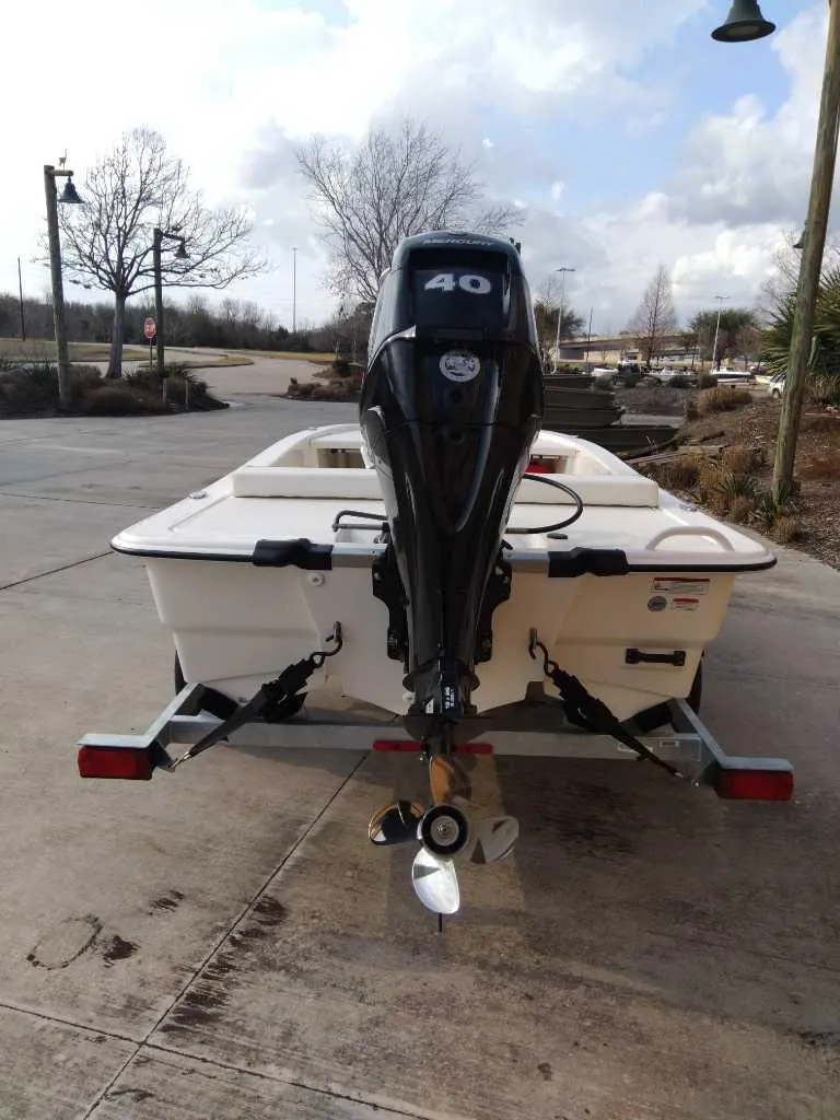 Slide: The Image of 2025 Mako Pro Skiff 13 CC boat with 40 HP outboard motor on trailer. - 4