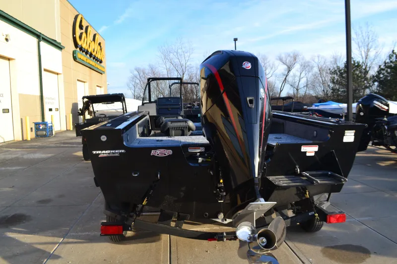 Slide: The Image of 2025 Tracker Targa V-19 WT boat, rear view, parked outside a store. - 2