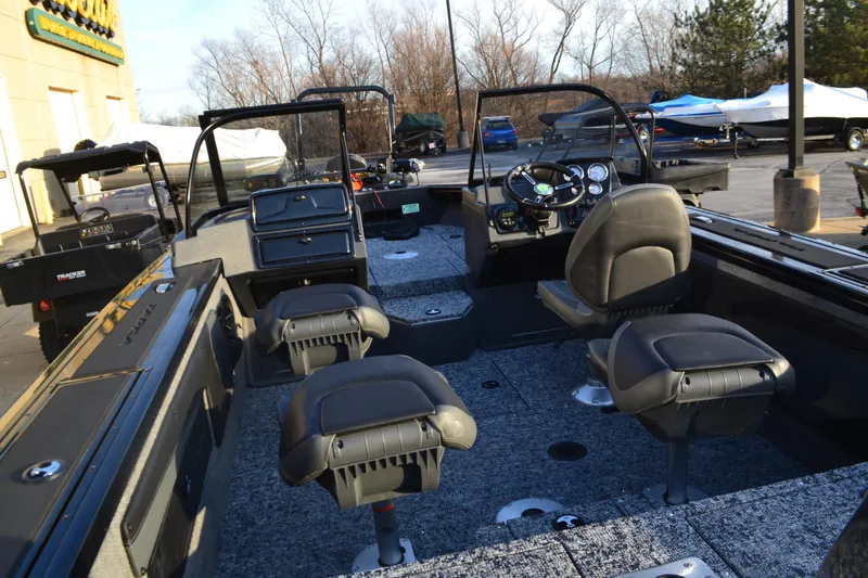 Slide: The Image of 2025 Tracker Targa V-19 WT boat interior with seating and dashboard, parked outdoors. - 3