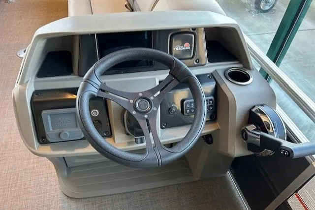 Slide: The Image of 2025 Sun Tracker Party Barge 22 DLX steering console with modern controls and cup holder. - 5