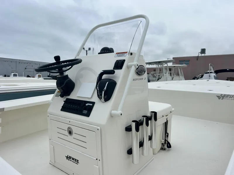 Slide: The Image of 2025 Hewes Redfisher 21 boat console with steering wheel and rod holders. - 2