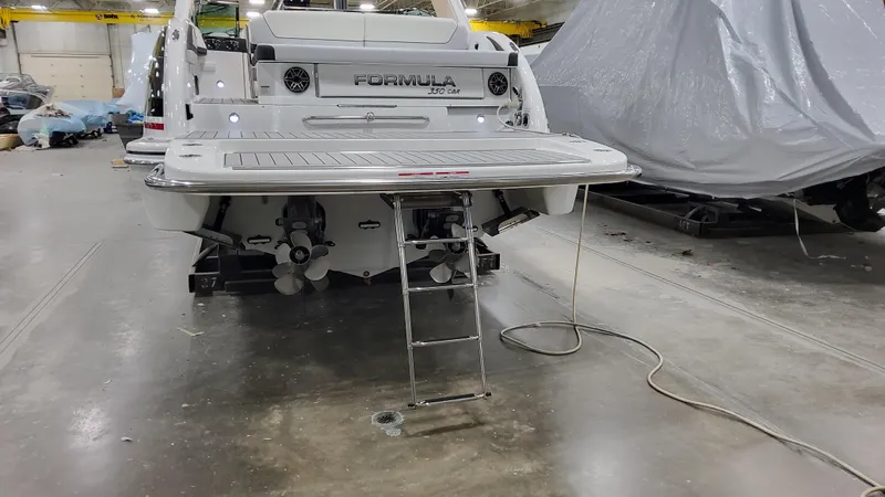 Slide: The Image of 2025 Formula 350 Crossover Bowrider I/O in a garage, rear view with swim platform. - 6
