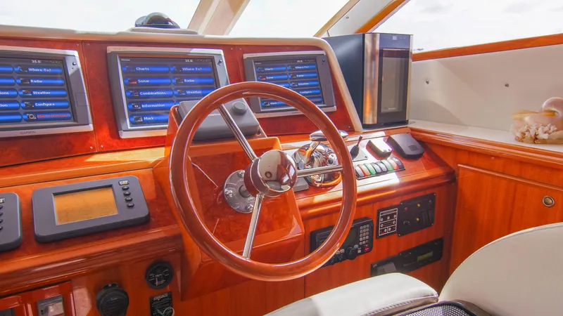 Slide: The Image of 2008 McKinna Pilothouse helm with wood finish, modern navigation screens, and steering wheel. - 16
