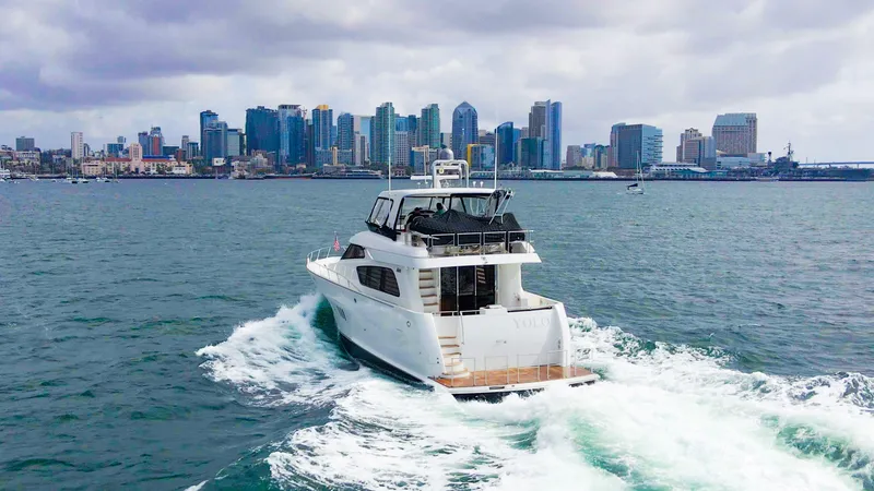 Slide: The Image of 2008 McKinna Pilothouse yacht cruising near a city skyline on a cloudy day. - 45