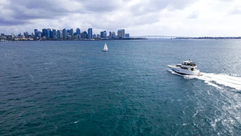 Slide: The Image of 2008 McKinna Pilothouse yacht cruising near city skyline and sailboat on open water. - 48