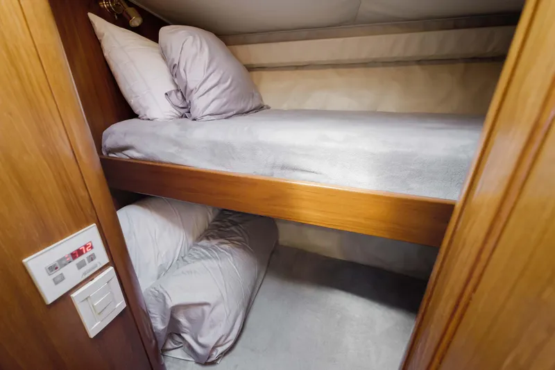 Slide: The Image of Bunk beds in 2005 Donzi 58 Express yacht cabin with wooden finish and cozy bedding. - 42