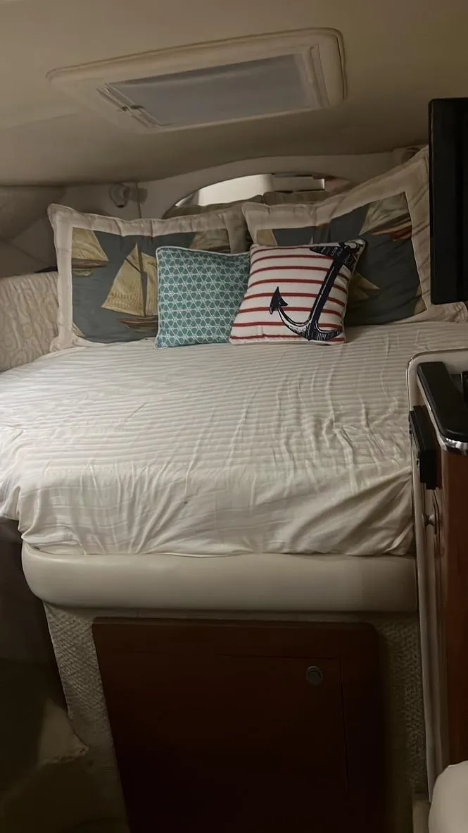 Slide: The Image of Interior cabin of 2005 Sea Ray 290 Amberjack with cozy bedding and decorative pillows. - 4