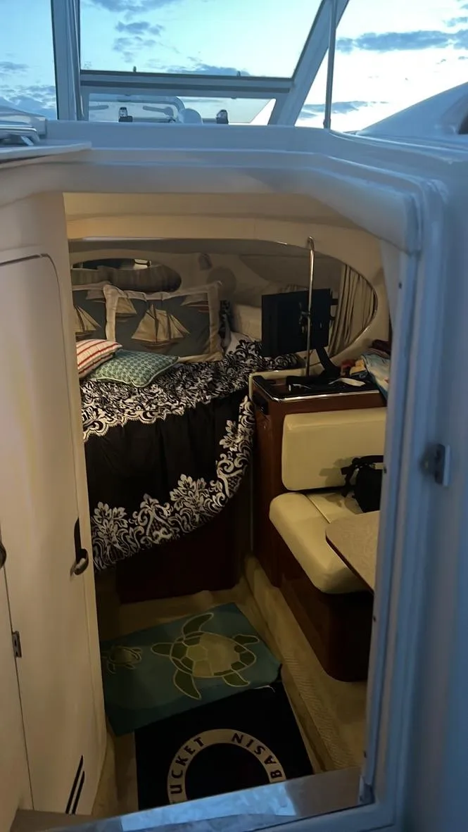Slide: The Image of 2005 Sea Ray 290 Amberjack cabin interior with cozy bedding and seating area. - 5