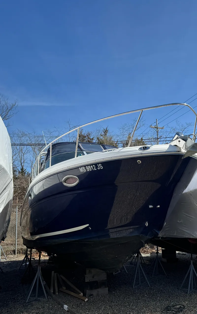 Slide: The Image of 2005 Sea Ray 290 Amberjack boat on stands, clear blue sky background. - 6