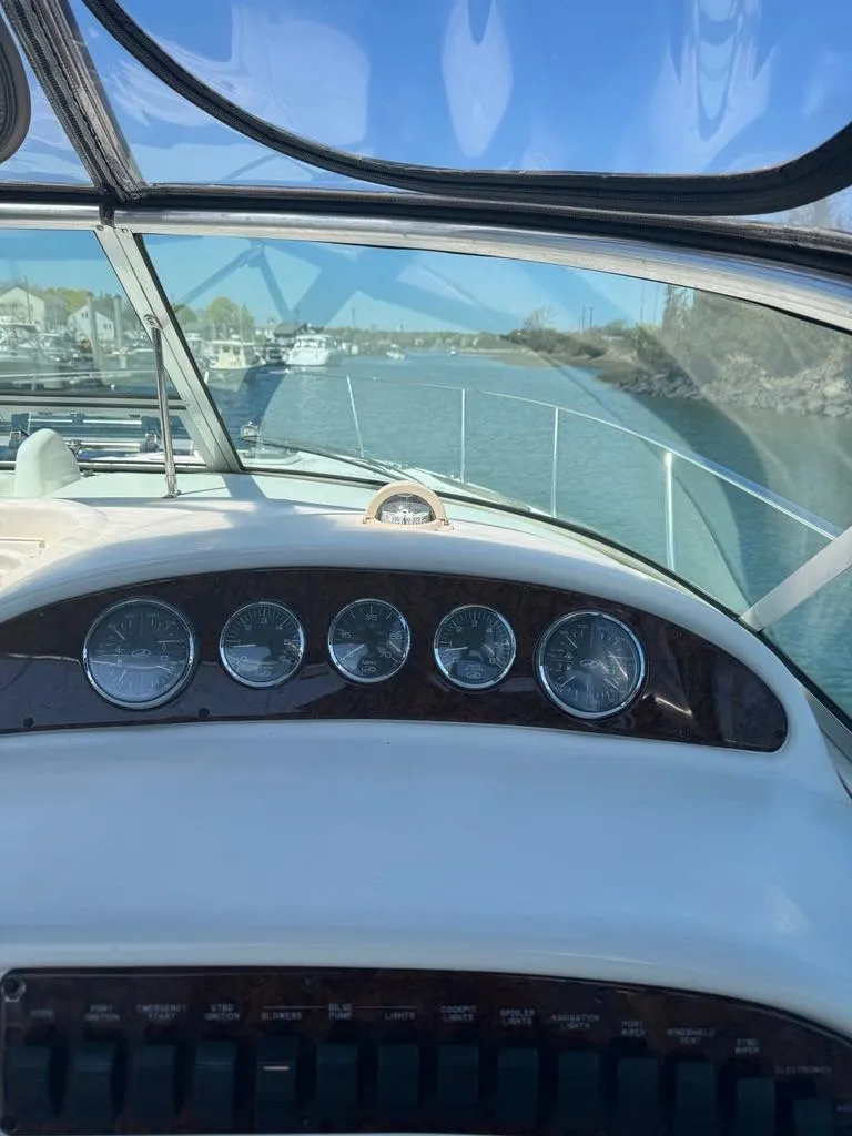 Slide: The Image of 2005 Sea Ray 290 Amberjack dashboard with gauges, cruising on a sunny day. - 7