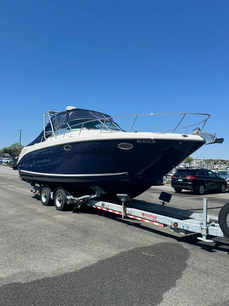 Slide: The Image of 2005 Sea Ray 290 Amberjack boat on trailer, parked outdoors under clear blue sky. - 8
